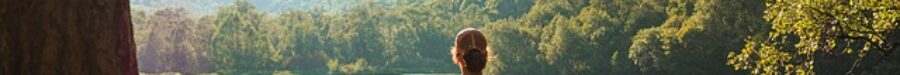 Person sitting calmly by a peaceful lake, symbolizing the tranquility and relaxation achieved through hypnotherapy for anxiety relief.