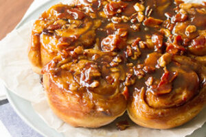 A close-up of a sticky bun with rich icing dripping down its caramelized sides, symbolizing indulgence and emotional eating. This image represents the temptation of comfort foods and how hypnosis can help manage cravings and emotional eating habits.